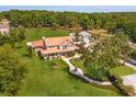 Aerial view of a sprawling property with a traditional home, detached garage, lush landscaping, and mature trees at 36408 E Eldorado Lake Dr, Eustis, FL 32736