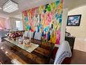 Spacious dining room featuring unique wall art, stylish chandelier, and hardwood floors at 405 Bella Vida Blvd, Orlando, FL 32828