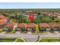 Aerial view of a property with a beautiful pond view in a community with tile roofs and lush landscaping at 411 Cabello Dr, Davenport, FL 33837