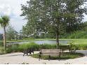Scenic view of a pond and park benches in a serene community setting at 5213 Northlawn Way, Orlando, FL 32811
