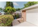 Townhome exterior featuring a brick accented garage and a meticulously maintained front garden at 604 Chestnut Oak Cir # 106, Altamonte Springs, FL 32701