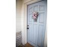 Charming pastel blue front door with a decorative floral wreath, creating an inviting entrance at 704 Beverly Ave, Altamonte Springs, FL 32701
