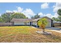 Charming one-story home with well-manicured lawn, complemented by a mature palm and vibrant blue front door at 975 N Elder Rd, Sanford, FL 32771