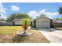 Well-maintained single-story home featuring a manicured front lawn, mature landscaping, and attached garage at 975 N Elder Rd, Sanford, FL 32771