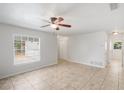 Open living space with tile flooring, ceiling fan, and natural light from the windows at 1051 Arden St, Longwood, FL 32750