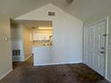 Living room featuring vaulted ceiling, view into kitchen, neutral walls and carpeting, and a white front door at 1081 S Hiawassee Rd # 726, Orlando, FL 32835