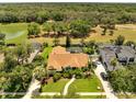 Aerial view of home with screened pool and mature trees, backing to a lake and green space at 1121 Arbor Glen Cir, Winter Springs, FL 32708
