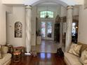 Elegant foyer with decorative columns, tile flooring, chandelier, and stained glass front doors at 1121 Arbor Glen Cir, Winter Springs, FL 32708