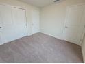 Bright bedroom with neutral carpet, double door closet, and white painted doors at 1264 Blue Island Dr, Clermont, FL 34714