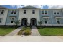 Attractive townhome showing a light blue exterior, covered entries, and colorful landscaping at 1286 Shoreside St, Clermont, FL 34714