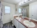 Bright bathroom with double sinks, a shower, and a separate toilet area at 143 Windsor Pl, Davenport, FL 33896