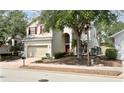 Charming two-story home with red shutters, a well-manicured lawn and a brick driveway at 143 Windsor Pl, Davenport, FL 33896
