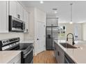Modern kitchen with stainless steel appliances, quartz countertops, and ample cabinet space at 14470 Sw 46Th Ct, Ocala, FL 34473