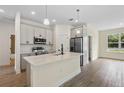 Stylish kitchen with a central island, stainless steel appliances, and modern pendant lighting at 14470 Sw 46Th Ct, Ocala, FL 34473