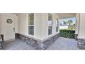 Covered porch with decorative stonework and a charming wreath on the front door at 14518 Black Quill Dr, Winter Garden, FL 34787