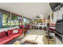 Bright and airy sun room perfect for relaxing, furnished with a sofa, table, and cat tree at 1620 Carolyn Ct, St Cloud, FL 34769