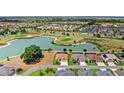 Aerial view showcasing a lake, golf course and houses, complimented by lush landscaping at 2086 Biller Cir, The Villages, FL 32163