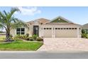 Charming single-story home with a three-car garage, landscaped yard, and brick-paved driveway at 2086 Biller Cir, The Villages, FL 32163