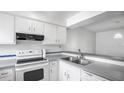 Well-lit kitchen with white cabinetry, updated appliances, and a functional layout at 316 Scottsdale Sq # 316, Winter Park, FL 32792