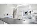 Efficient kitchen layout with white cabinets, gray counters, and essential appliances for easy meal prep at 316 Scottsdale Sq # 316, Winter Park, FL 32792