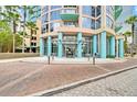 Elegant building entrance with teal pillars and a glass awning over a brick paved drive at 322 E Central Blvd # 1909, Orlando, FL 32801