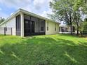 Spacious backyard with lush green grass, a screened patio, and a black metal fence at 3506 Creswick Cir, Orlando, FL 32829