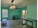Open living room with unique light fixture and sliding glass doors to the outside at 3586 Eversholt St, Clermont, FL 34711
