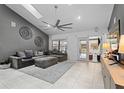 Spacious living room with a large gray sofa, area rug, and sliding glass doors to the backyard at 408 S Winsome Ct, Lake Mary, FL 32746