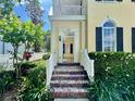 Inviting front porch with classic brick steps, lush landscaping, and an open doorway to the home's interior at 508 Sycamore St, Celebration, FL 34747