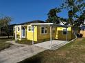 Bright yellow house with white carport and trim, offering a vibrant and modern exterior at 5216 Davisson Ave, Orlando, FL 32810