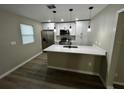 Modern kitchen features white cabinets, quartz countertops and stainless steel appliances at 5216 Davisson Ave, Orlando, FL 32810