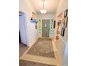 Bright entryway featuring a decorative front door, tile floor, and carpet at 600 Lake St, Fruitland Park, FL 34731