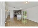 Open-concept living room featuring neutral paint, tile floors and sliding glass doors at 6148 Landrace Ln, Orlando, FL 32807