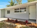 A close-up of a freshly painted home showcasing the front door and landscaping at 75 Garrison Ln, Frostproof, FL 33843
