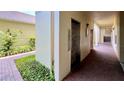 Building exterior with an elevator entrance, brick pathway, and manicured landscaping at 921 Begonia Rd # 302, Celebration, FL 34747