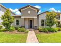 Inviting single-Gathering home featuring stone accents, lush landscaping and a brick pathway at 9544 Mere Pkwy, Orlando, FL 32832