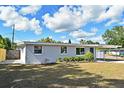 Charming single-story home featuring a well-manicured lawn, blue door, and a convenient carport at 994 Lormann Cir, Longwood, FL 32750