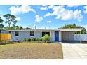 Charming single-story home featuring a well-manicured lawn, blue door, and a convenient carport at 994 Lormann Cir, Longwood, FL 32750