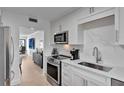 Modern kitchen with white cabinets, stainless steel appliances, and an open layout leading to the dining area at 100 S Interlachen Ave # 410F, Winter Park, FL 32789