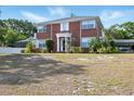 Charming two-story red brick home with a well-manicured lawn and welcoming front entrance at 1002 Lake Elbert Se Dr, Winter Haven, FL 33880