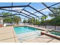 Inviting screened pool area with clear blue water and a relaxing spa, surrounded by lush landscaping at 1002 Lake Elbert Se Dr, Winter Haven, FL 33880