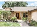 Inviting front exterior with brick and siding, manicured lawn, and a pathway to the entrance at 10049 Custer Cir, Orlando, FL 32817