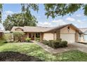 Charming single-Gathering home with brick accents, well-maintained landscaping, and a two-car garage at 10049 Custer Cir, Orlando, FL 32817