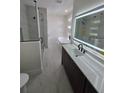 Sleek bathroom features a glass-enclosed shower, soaking tub, and modern vanity with illuminated mirror at 1005 Randall St, Orlando, FL 32805