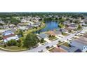 Overhead view of houses in a lakeside residential neighborhood with mature trees and landscaping on a sunny day at 1021 Whalebone Bay Dr, Kissimmee, FL 34741