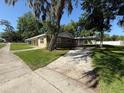 Single-story home with a covered porch and a driveway leading to a carport on the right side at 1108 Bear Lake Rd, Apopka, FL 32703