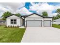 Charming home featuring a two-car garage, inviting facade, and manicured lawn at 13312 Sw 41St Ct, Ocala, FL 34473