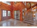 Grand foyer with a striking wood accent wall, stone floors, a modern staircase, and a bright entryway at 13377 Lake Butler Blvd, Winter Garden, FL 34787
