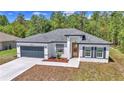 Lovely single-story home showcasing a modern design, a two-car garage, and fresh landscaping at 13430 Sw 88Th Ter, Ocala, FL 34473