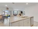 Open-concept kitchen island with a double sink, granite countertop, and seamless connection to the living area at 1535 Barberry Dr, Kissimmee, FL 34744